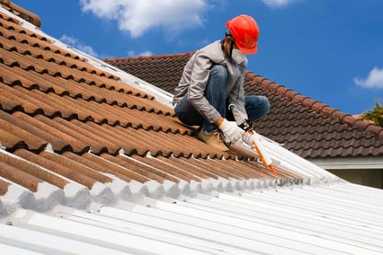 Technician-man-hand-using-glue-gun-with-silicone-adhesive-or-manual-caulking-gun-with-polyurethane-to-seal-the-leak-on-the-roof